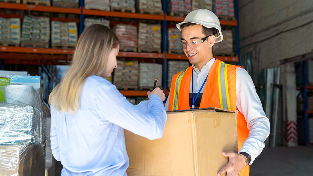 Female client of delivery service picks up the goods from the warehouse and signs the waybill